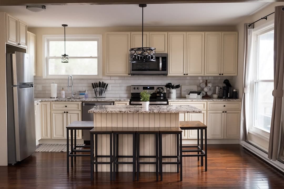 Clean kitchen with cream cabinets and granite island after residential cleaning